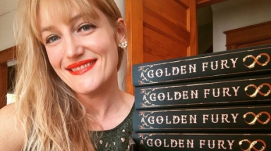 Samantha Cohoe next to a stack of copies of "A Golden Fury"