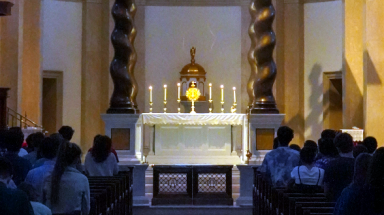 Students adore the Blessed Sacrament, exposed for Adoration, in the nighttime Chapel