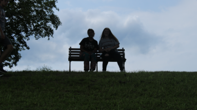 Silhouetted against the sky: two students on a park bench