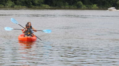 Two students in a kayak out on the open water