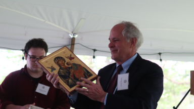 Dr. Kaiser receives the Marian icon from a student