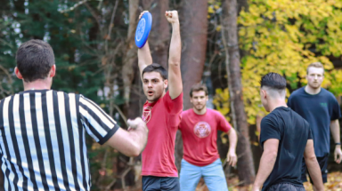 A student cheers, frisbee in hand