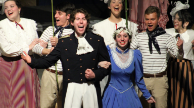 The cast sings, with a sailor and girl in blue in the foreground