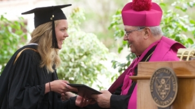 Graduate receives her diploma from Bishop Morlino © 2018 by 