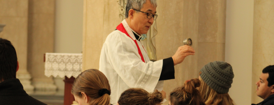 Fr. Chung blesses students with the relic before finals